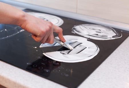 Nettotage d'une plaque à induction avec un grattoir
