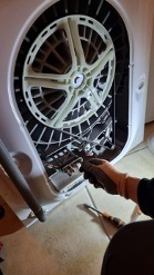Le technicien insère une résitance neuve dans le lave-linge