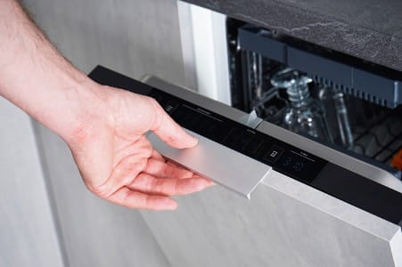 Une personne vérifie la porte de son lave-vaisselle 